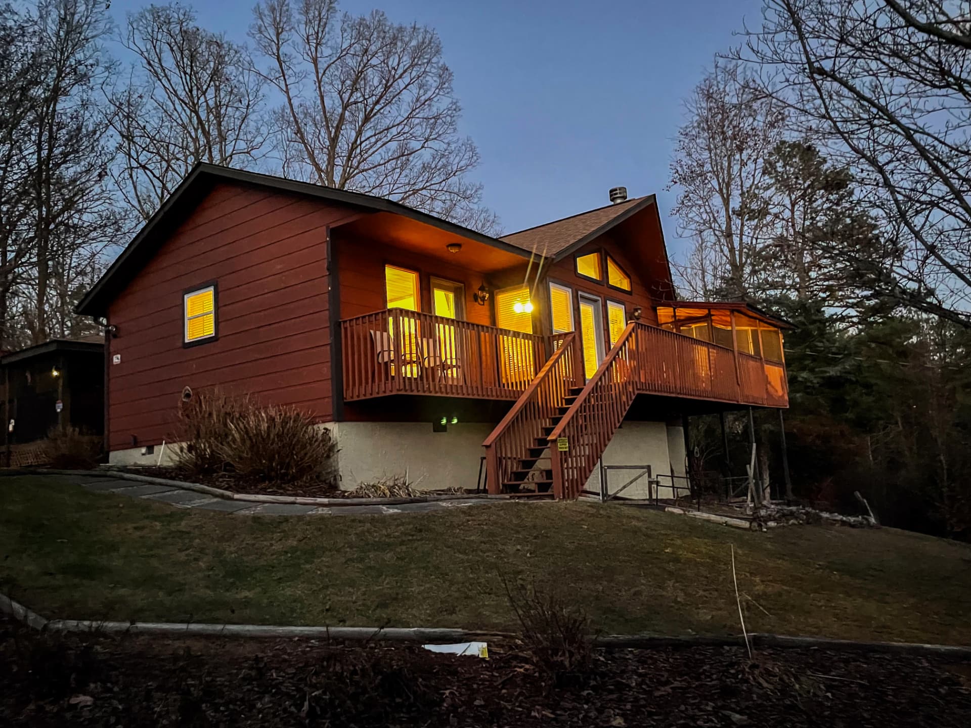 Short-term rental cabin exterior with porch and deck in warm evening light